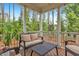 Inviting covered porch with comfortable seating and a view of the serene, tree-lined backyard at 208 Cecelia Ct, Cary, NC 27519