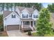 Charming two-story home with blue siding, a covered porch, and a well-manicured front yard at 208 Cecelia Ct, Cary, NC 27519
