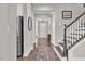 Hallway features hardwood floors, staircase access, and flows into the kitchen and front entryway at 208 Cecelia Ct, Cary, NC 27519