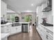 Bright, spacious kitchen with white cabinets, stainless steel appliances, hardwood floors and view to living area at 208 Cecelia Ct, Cary, NC 27519