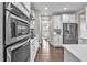 Gourmet kitchen featuring modern stainless steel appliances, sleek white cabinetry, and hardwood floors at 208 Cecelia Ct, Cary, NC 27519