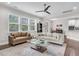 Bright open-concept living room with large windows flowing into dining and kitchen at 208 Cecelia Ct, Cary, NC 27519