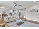 Bright, open-concept living room featuring a modern ceiling fan and hardwood floors at 208 Cecelia Ct, Cary, NC 27519