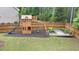 Backyard with a wooden playground, a slide, swings, and lush greenery for hours of outdoor fun at 208 Cecelia Ct, Cary, NC 27519