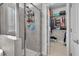 Modern tile shower adjacent to a walk-in closet with ample storage shelves and hanging space at 208 Cecelia Ct, Cary, NC 27519