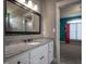 Bathroom vanity with granite countertop, white cabinets, and a large framed mirror offers style and functionality at 2109 Taramar Ln, Zebulon, NC 27597