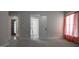 A serene bedroom with neutral tones, soft carpet, and a glimpse of the entry creates a calming and inviting atmosphere at 2109 Taramar Ln, Zebulon, NC 27597