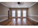 Bright, spacious living room with hardwood floors, three windows and a ceiling fan at 2109 Taramar Ln, Zebulon, NC 27597