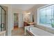 Bathroom area with a bathtub, vanity, and decorative window providing natural light at 220 Cole Valley Dr, Cary, NC 27513