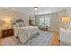 Bedroom featuring a bed, lamps, dresser, accent chair, and an area rug on hardwood flooring at 220 Cole Valley Dr, Cary, NC 27513