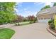 Spacious driveway leading to a brick home with a white garage door and lush landscaping at 220 Cole Valley Dr, Cary, NC 27513