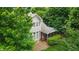 Rear exterior view of the home surrounded by lush trees, highlighting the patio and screened-in porch at 220 Cole Valley Dr, Cary, NC 27513