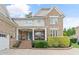 Inviting brick home featuring a cozy front porch, manicured landscaping, and a bright blue front door at 220 Cole Valley Dr, Cary, NC 27513