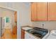 Laundry room with sink and access to a half bathroom and wooden cabinets at 220 Cole Valley Dr, Cary, NC 27513