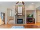Cozy living room featuring a stone fireplace and adjacent staircase to second level at 220 Cole Valley Dr, Cary, NC 27513