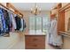 View of walk-in closet with custom built-in wooden shelving, chandelier, and central drawer unit at 220 Cole Valley Dr, Cary, NC 27513