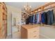 Bright walk-in closet with custom built-in wooden shelving and drawers, offering ample storage space at 220 Cole Valley Dr, Cary, NC 27513
