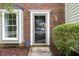 Close up of front door next to window with meticulously arranged mulch beds add curb appeal to this home at 2201 Alpine Rd, Durham, NC 27707