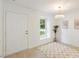 Bright entryway featuring a white front door, complementing light hardwood flooring and natural light from a window at 2201 Alpine Rd, Durham, NC 27707