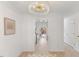 Bright hallway illuminated by a modern chandelier, flowing into the kitchen with views of the backyard patio at 2201 Alpine Rd, Durham, NC 27707
