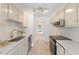 Kitchen with marble countertops, white cabinets, stainless steel appliances, and view to the front of the property at 2201 Alpine Rd, Durham, NC 27707
