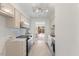 Galley kitchen features white cabinets, marble countertops, stainless steel appliances, and access to the backyard at 2201 Alpine Rd, Durham, NC 27707
