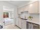 Bright kitchen offering white cabinets, marble countertops, stainless appliances, and backyard access at 2201 Alpine Rd, Durham, NC 27707