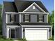 Two-story home boasts a welcoming facade, a two-car garage, classic shutters, and manicured landscaping at 221 Steel Springs Ln # 23, Angier, NC 27501