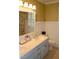 Bathroom with double sinks, vintage blue cabinetry, and a large framed mirror at 2216 Countrywood North Rd, Raleigh, NC 27615