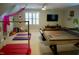 Spacious bonus room with ping pong table, TV, fan, and gymnastic equipment at 2216 Countrywood North Rd, Raleigh, NC 27615