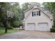 Exterior view of a home with a two-car garage, basketball hoop, and mature trees at 2216 Countrywood North Rd, Raleigh, NC 27615
