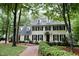Stately two-story home featuring dormer windows, black shutters, manicured landscaping, and a brick pathway at 2216 Countrywood North Rd, Raleigh, NC 27615