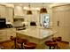 Bright kitchen with marble countertops, island with seating, stainless steel appliances, and custom cabinets at 2216 Countrywood North Rd, Raleigh, NC 27615