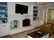 Living room with a white brick fireplace, built-in shelving, and a large television for entertainment at 2216 Countrywood North Rd, Raleigh, NC 27615