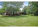 Large, well-manicured backyard with a view of the back of the house, including the deck at 225 Norwalk St, Holly Springs, NC 27540