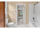 Bathroom featuring a bathtub and shower, white tile, and a view into a bedroom at 225 Norwalk St, Holly Springs, NC 27540