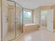 Luxurious bathroom with a glass shower, a soaking tub and a patterned window at 225 Norwalk St, Holly Springs, NC 27540