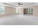 Large bedroom with trey ceiling, ceiling fan, large windows, and plush carpet at 225 Norwalk St, Holly Springs, NC 27540