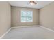 Neutrally decorated bedroom featuring a single window, neutral carpet, and ceiling fan at 225 Norwalk St, Holly Springs, NC 27540