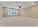 Large bedroom with light-colored walls, neutral carpet, and a ceiling fan for comfort at 225 Norwalk St, Holly Springs, NC 27540