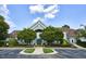 Community clubhouse surrounded by lush greenery and well-maintained landscaping and ample parking at 225 Norwalk St, Holly Springs, NC 27540