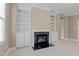 Cozy living room featuring a fireplace with dark granite, built-in shelves, and carpet floors at 225 Norwalk St, Holly Springs, NC 27540