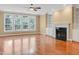Bright living room features wood floors, large windows, a fireplace, and built-in shelving at 225 Norwalk St, Holly Springs, NC 27540