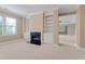 Spacious living room featuring a cozy fireplace, built-in shelves, and large windows at 225 Norwalk St, Holly Springs, NC 27540