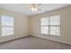 A standard bedroom featuring neutral carpet, walls, and large windows at 229 Michigan Ave, Cary, NC 27519