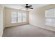 Bright bedroom featuring neutral walls, carpeted floors, a ceiling fan, and natural light through multiple windows at 229 Michigan Ave, Cary, NC 27519