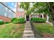 Inviting townhouse entrance with concrete steps, black door, and manicured shrubs at 229 Michigan Ave, Cary, NC 27519