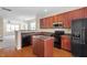 Modern kitchen with island, cherry cabinets, and stainless steel appliances at 229 Michigan Ave, Cary, NC 27519