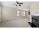 Open concept living room with fireplace, ceiling fan, and view to the kitchen at 229 Michigan Ave, Cary, NC 27519