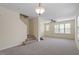 Spacious living room featuring carpet, stairs to second floor, and a ceiling fan at 229 Michigan Ave, Cary, NC 27519